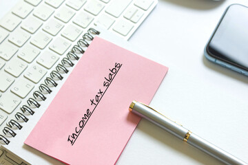 Income tax slabs inscription on a notebook