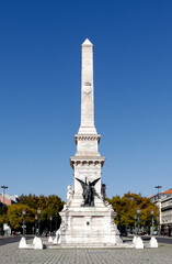 Fototapeta na wymiar Obelisk at Praca dos Restauradores in Lisbon commemorates Portugala's liberation from Spanish yoke in 1640. The bronze figures on the pedestal depict Victory holding a palm and crown
