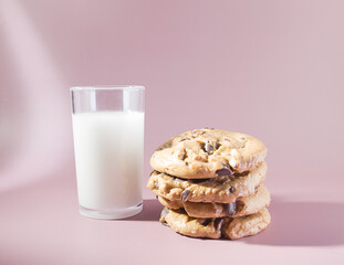 A Chocolaty Treat: A Glass of Milk and a Stack of Decadent Chocolate Chip Cookies on a Pastel Background