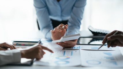 Business teamwork brainstorming meeting process. Business people discussing the charts and graphs showing the results of their successful teamwork.