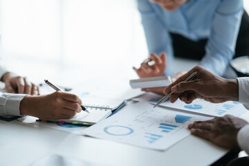 Business teamwork brainstorming meeting process. Business people discussing the charts and graphs showing the results of their successful teamwork.