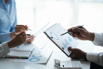 Business teamwork brainstorming meeting process. Business people discussing the charts and graphs showing the results of their successful teamwork.