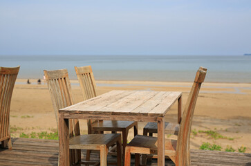Empty wood table and chairs at restaurants near the beach.