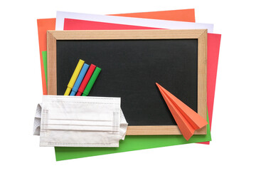 School stationery with blackboard, magic colors, colored papers, origami and face mask. Top view,...