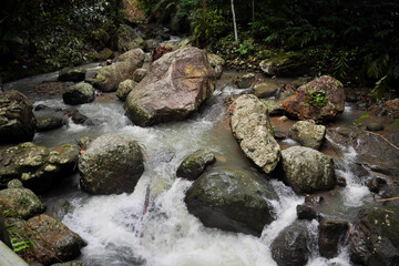 A clear view of the river and the large rocks in the center. the natural atmosphere of the countryside in Indonesia