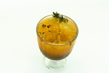 Passionfruit juice in glass and fresh passion fruit with green leaf isolated on wooden table background.