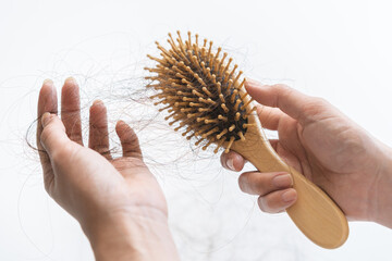 Serious asian young woman, girl hand in holding comb, show her hairbrush with long loss hair problem after brushing, hair fall out problem. Health care, beauty with copy space on floor background.