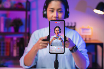 Vlogger live streaming podcast review on social media, Young Asian woman use microphones wear headphones with smartphone record video. Content creator concept. - obrazy, fototapety, plakaty