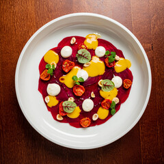 beetroot carpaccio with sauce, on white plate