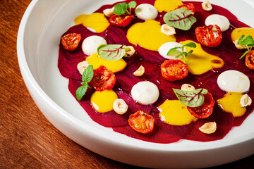 beetroot carpaccio with sauce, on white plate