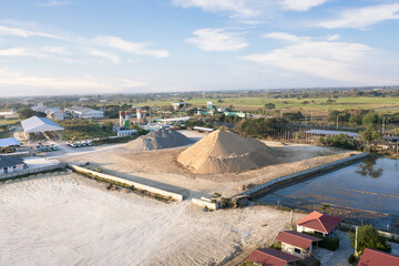 Pile of sand and rock or gravel in concrete plant with sky background in aerial view. Heap of...