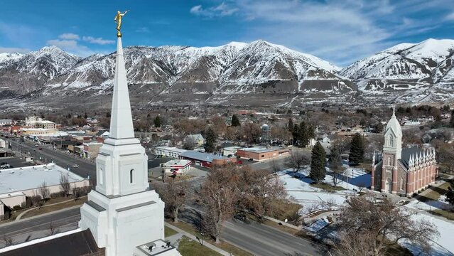 Aerial Brigham City Utah LDS Temple forward 2. The Church of Jesus Christ of Latter-day Saints, LDS or Mormon Church. Spiritual sacred church. Urban neighborhood in mountain valley. Winter snow.