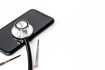 Fototapeta na wymiar Electronics repair servise concept - mobile phone with stethoscope