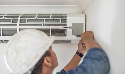 Air conditioner, ac repair and maintenance of a handyman and builder working on home renovation. Electric technician, service worker and contractor in a house for equipment installation on wall - obrazy, fototapety, plakaty