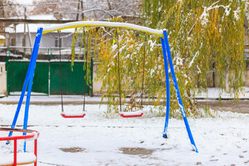 Snow on the swings. Winter background, selective focus