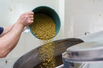 The process of adding malt to a vat at a brewery, motion blur, steam from brewing beer. Background