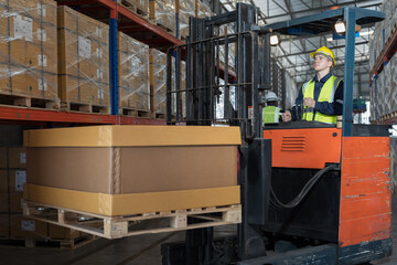 Male warehouse worker driving and operating on forklift truck for transfer products or parcel goods...
