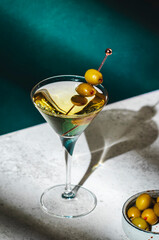 Vodka martini, classic alcoholic cocktail drink with vodka and vermouth, green olives garnish, dark...