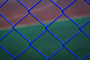 Fototapeta premium A blue mesh netting encloses the sports ground.