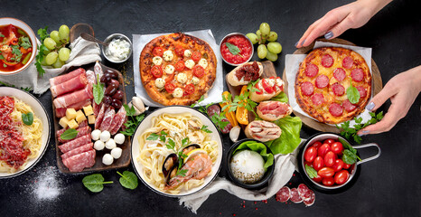 Italian food dishes on dark background.