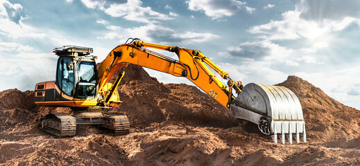 A large yellow crawler excavator moving stone or soil in a quarry. Heavy construction hydraulic...