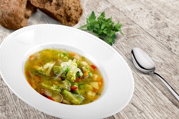 Tasty fresh soup dish in plate with bread