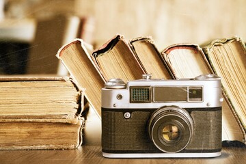 Old fashioned camera on bookshelf with retro books