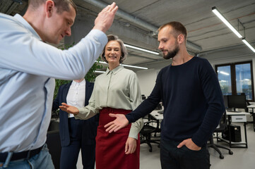Four co-workers give a high five in the office.