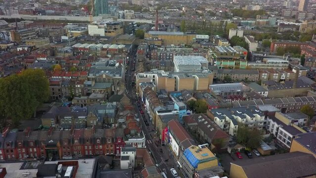 Aerial rises over Brick Lane district in London UK, looking northward