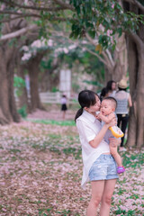 Asia Mother and baby in the park with Pink trumpet tree