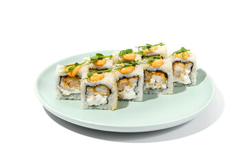 Maki sushi with sesame outside, tempura shrimp inside topped spicy sauce and microgreens. Spicy shrimp maki roll on ceramic plate isolated on white background Sushi roll with crispy prawn on plate