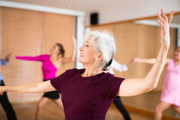 elderly woman and her partner successfully perform mesmerizing movements of paso doble dance