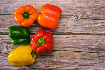 Group of peppers of different colors on a wooden table. Bell peppers of different colors.