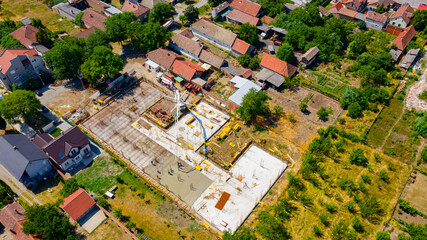 Fototapeta premium Above view pouring fresh concrete into building foundation over reinforcing steel bars