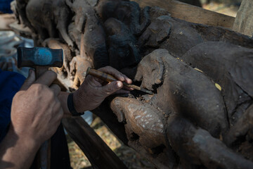 Carpenter's hands Man professional during working woodcarving Elephant on the Wooden for decoration home or office as Antique Interior furniture for the vintage room.