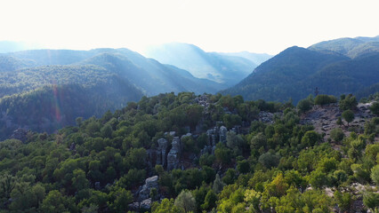 Aerial panoramic view of forested mountains slopes with rock formations. Spectacular nature background.