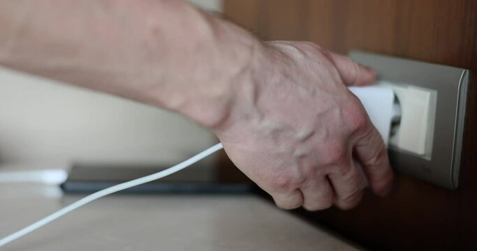 Man hand takes out charger for mobile phone