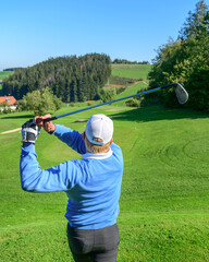 Golfspieler spielt einen Ball mit einem Eisen vom Tee