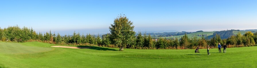 Fototapeta na wymiar Panorama einer Spielbahn beim Golf mit einer Spielgruppe