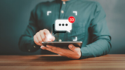 Young man hand using a tablet typing live chat chatting on application communication speech bubble digital web and social network concept. Social media application chat box on tablet.