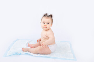 baby in diapers sitting on a disposable diaper on a white insulated background, space for text,...