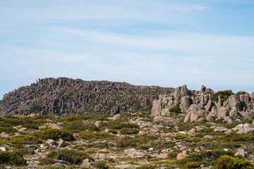 Fototapeta na wymiar peak of a rocky mountain in a national park looking over a city below, mt wellington hobart tasmania australia