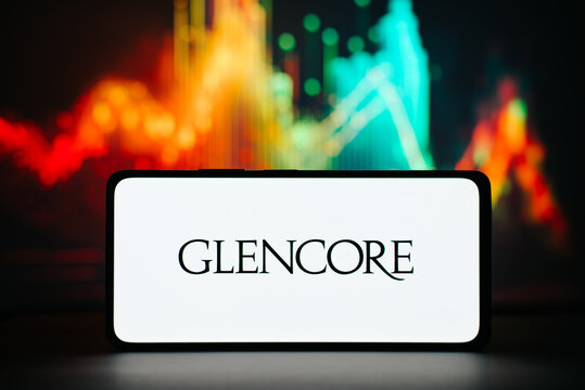 Glencore and investment, financial business concept. Logo of Swiss company Glencore on smartphone against background of stock exchange chart, trading view. Astana, Kazakhstan 20.02.2023