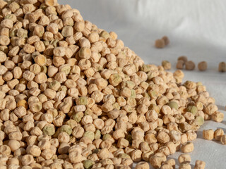 A pile of dried pea seeds on a white cloth close-up