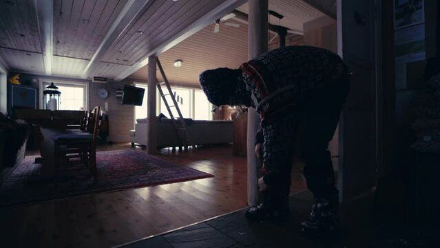 Man Removing Snow Boots Inside The House. wide