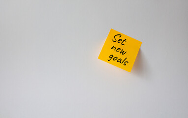 Set New Goals symbol. Concept words Set New Goals on orange steaky note. Beautiful white background. Business and Set New Goals concept. Copy space.