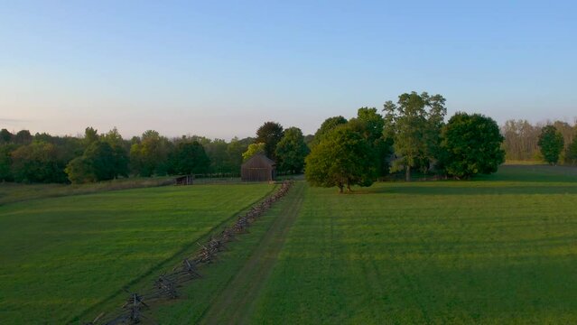 drone move in closer to next to a fence near the Joseph Smith family farm, frame house, temple, visitors center, and the sacred grove in Palmyra New York Origin locations  the book of Mormon.