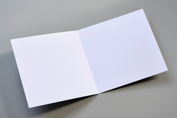 Laying blank open empty square greeting card mock up on grey background. For use as a Christmas,...