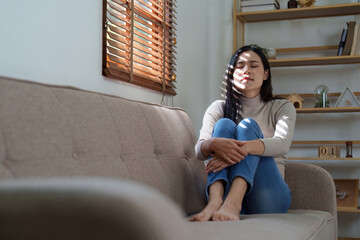 Obraz premium Unhappy female overworked and stressed sit at sofa at home. headache, depression feeling exhausted frustrated with bad news, failure at work