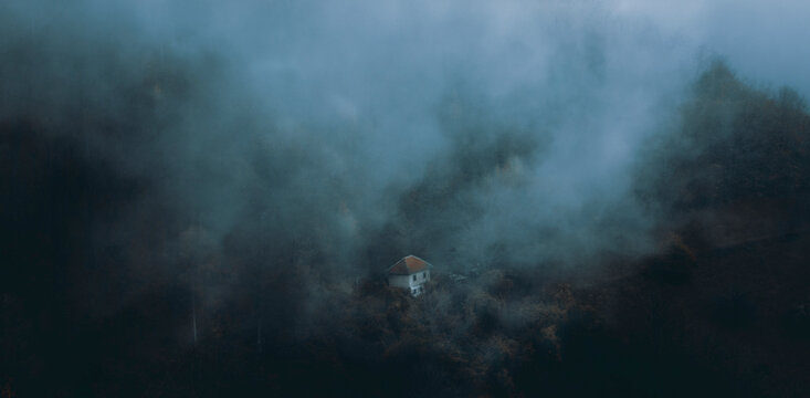 Little house on the slope during the withdrawal of a fog.